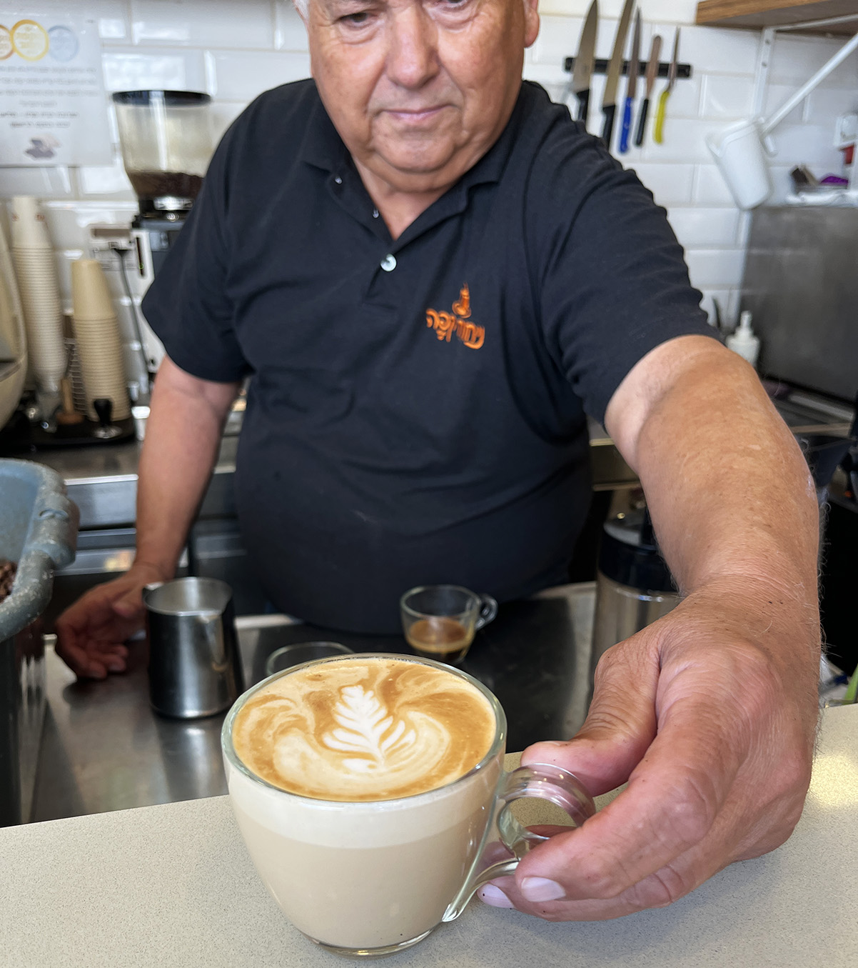 אריה סעת מכין קפוצ'ינו בבית הקפה שלו בזכרון יעקב. צילום: דיקלה דנינו