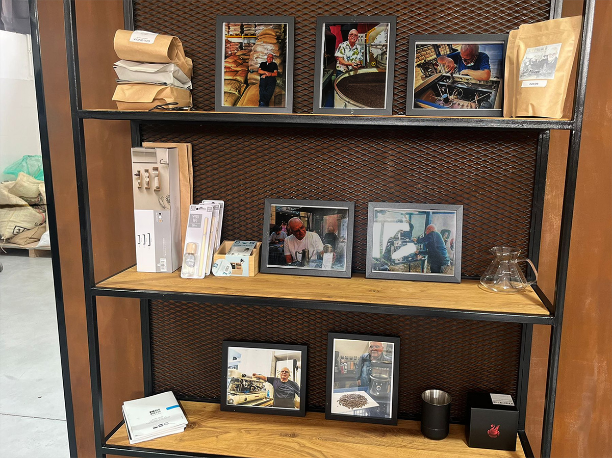 קיר מיוחד עם תמונות של מאוריציו - קולה, מתקן מכונות, מכין קפה ומתעסק עם קפה ירוק. צילום: אנירן ארליך