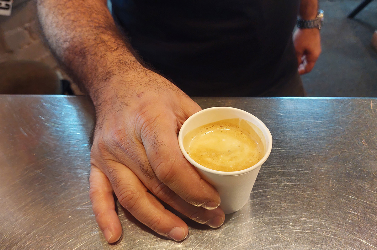 אספרסו ארוך עם נגיעה של חלב מוקרם בכוס לקחת. צילום: איתי שקד