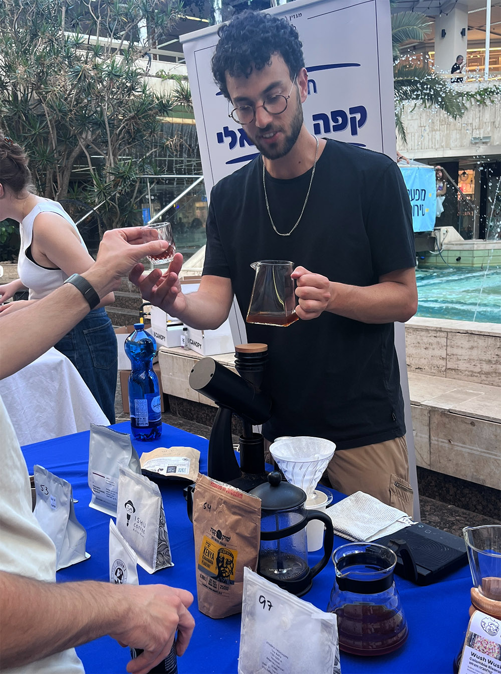 הבריסטה יותם גולדפרב בדוכן של תחרות "הקפה הטוב" בתערוכת "קפה ישראלי" 2026 (צילום: דיקלה דנינו)