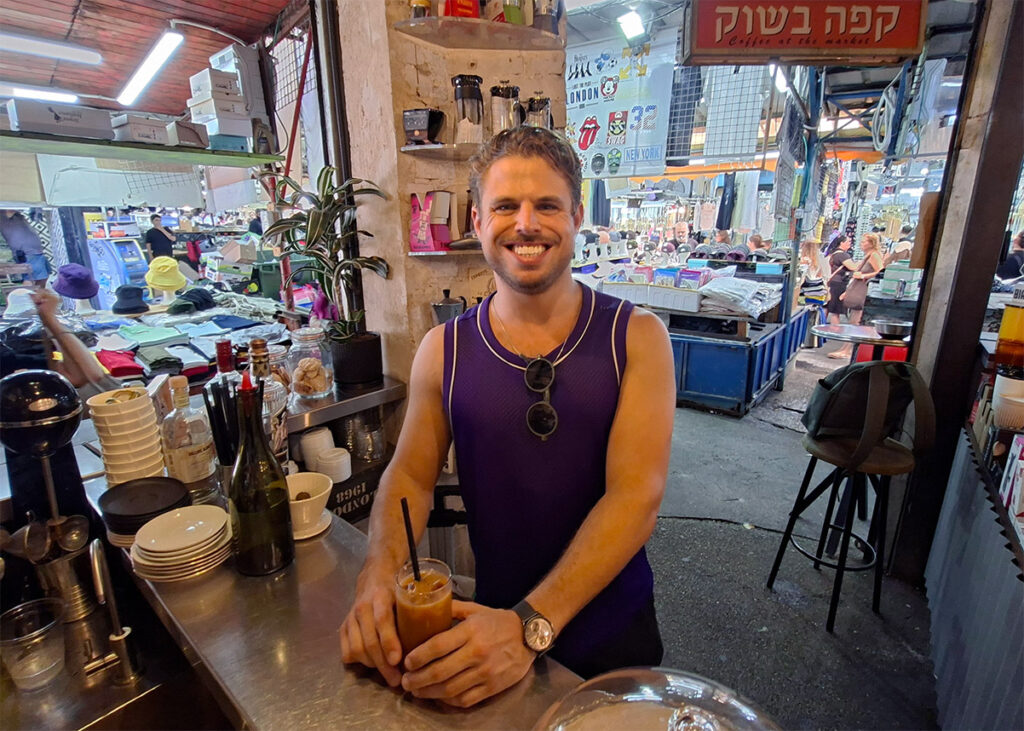 גד רייך עם אמריקנו קר בקפה בשוק הכרמל (צילום: איתי שקד)