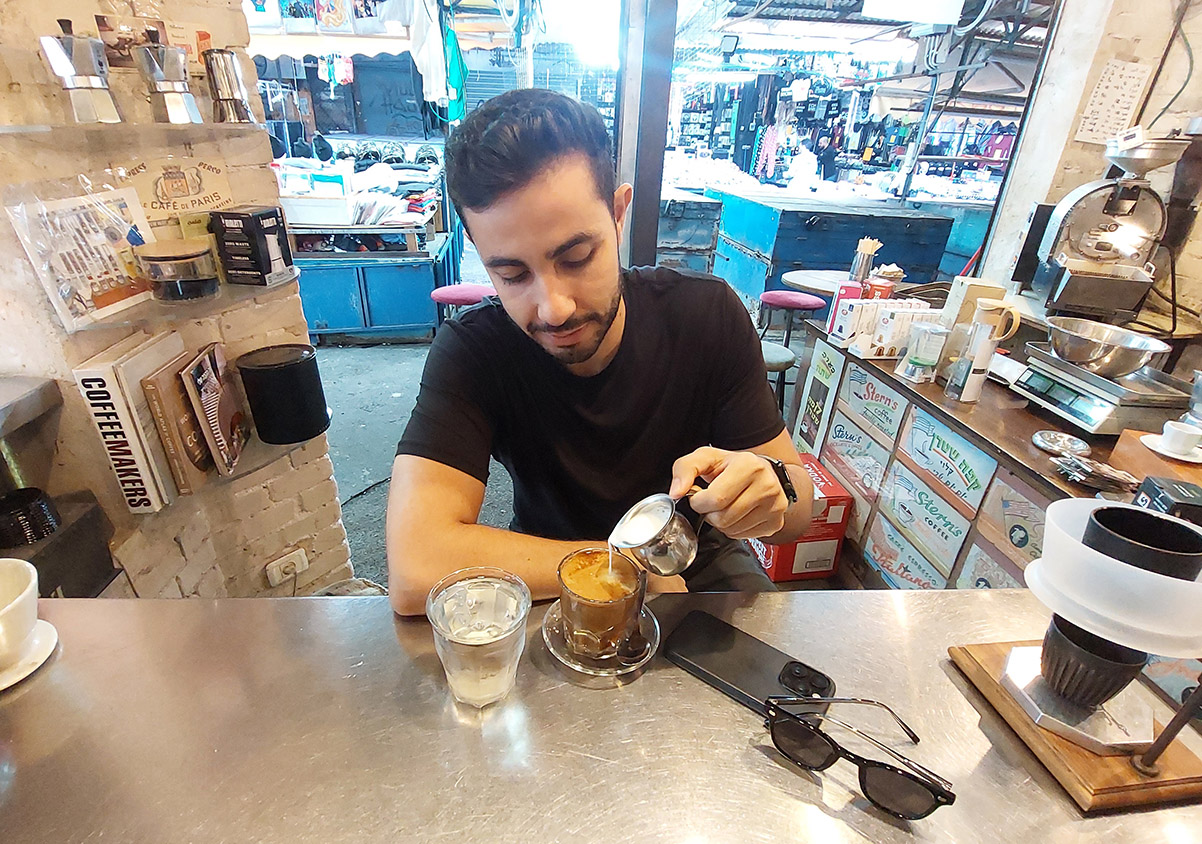 אדם לוי שותה אמריקנו קטן עם חלב בשוק הכרמל בתל אביב. צילום: איתי שקד