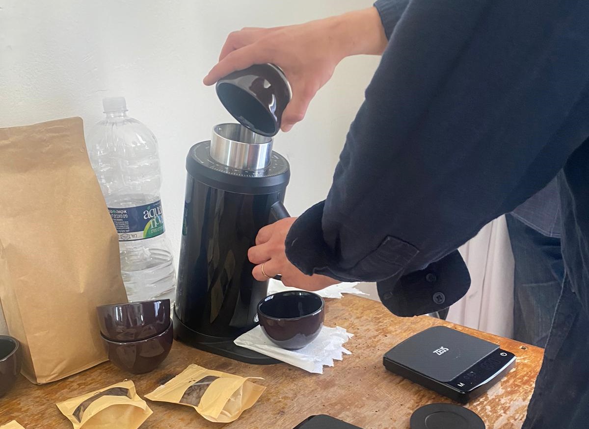 הבריסטה טוחן את פולי הקפה לפני הטעימות בקאפינג. צילום: אורלי דוד