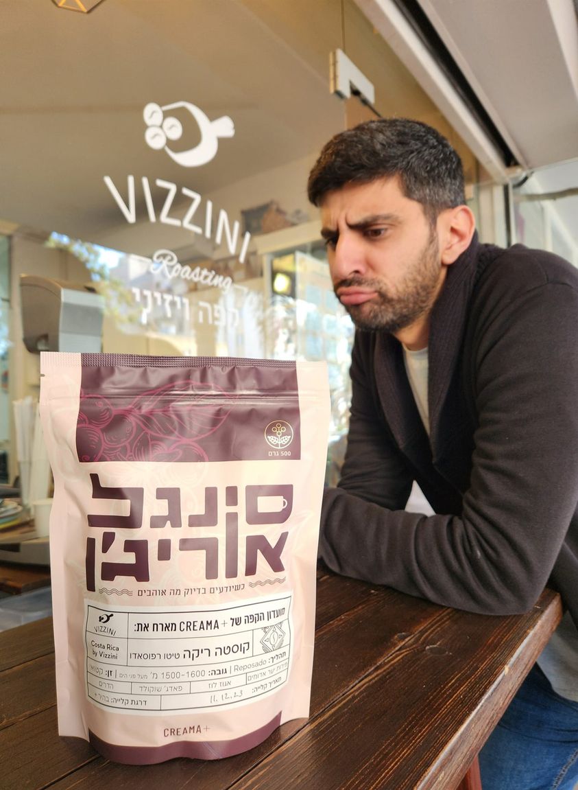 אלעד לוי מקפה ויזיני ושקית פולי קפה מסדרת מועדון הקפה של קרמה פלוס. צילום: מתוך הפייסבוק של Vizzini Cafe